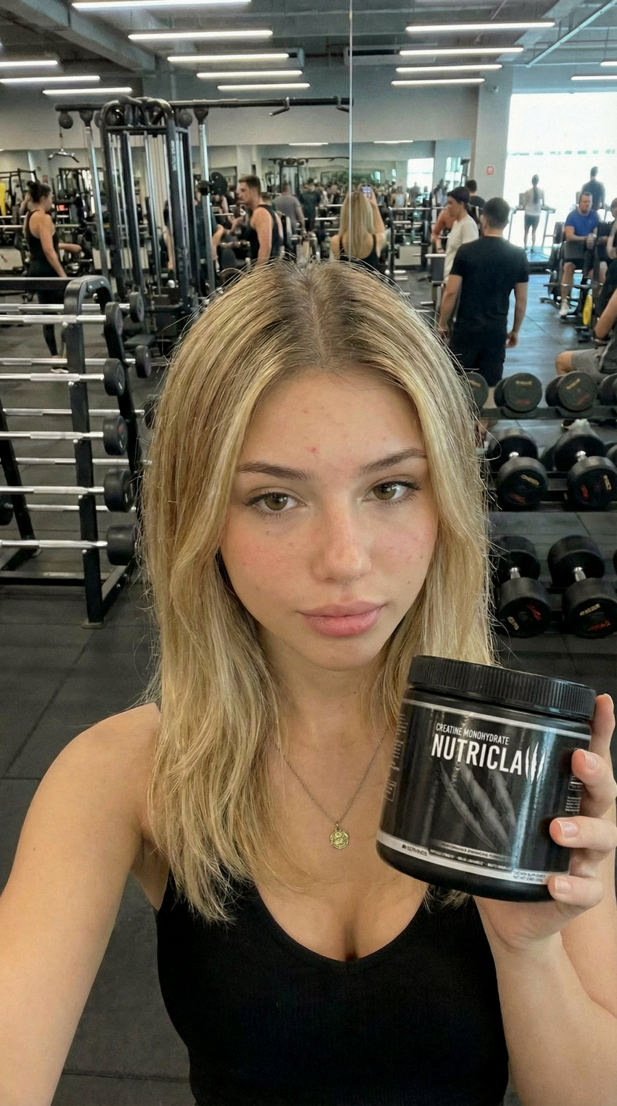 Woman at the gym holding NutriClaw Creatine Monohydrate