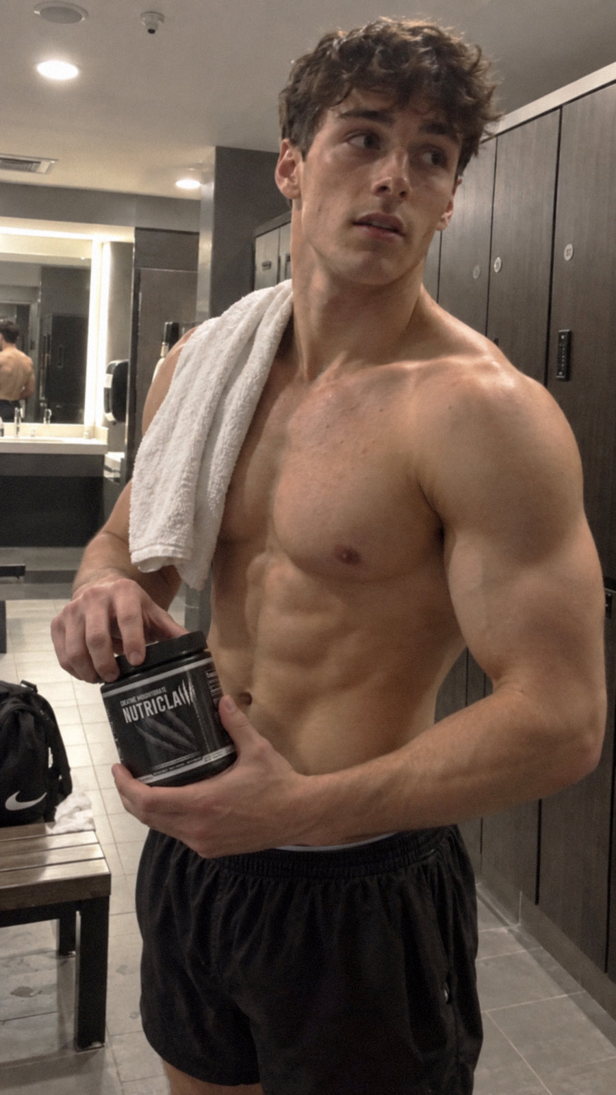 Athletic man holding a NutriClaw supplement container